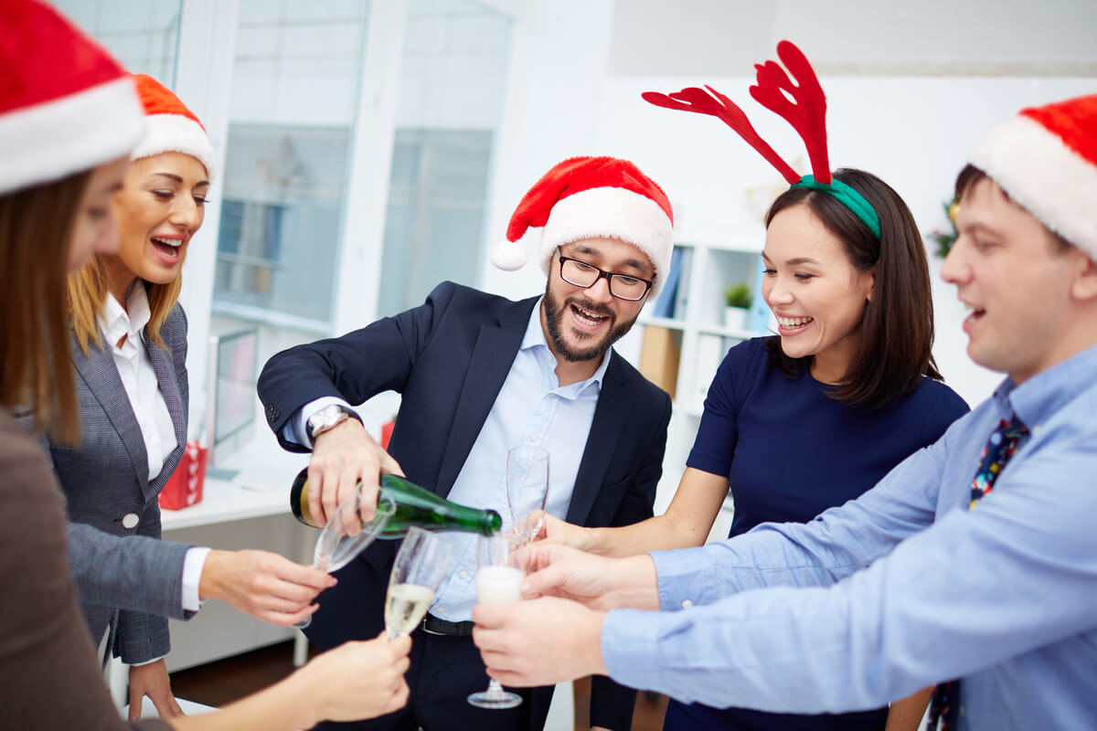 group of employees at an office holiday party drinking and smiling
