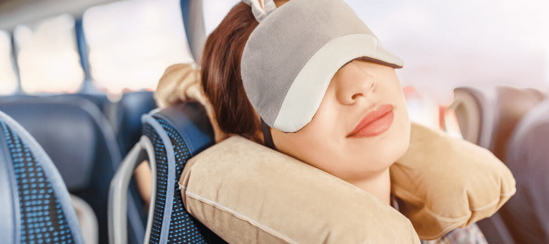 woman in sleep mask sleeping on a charter bus