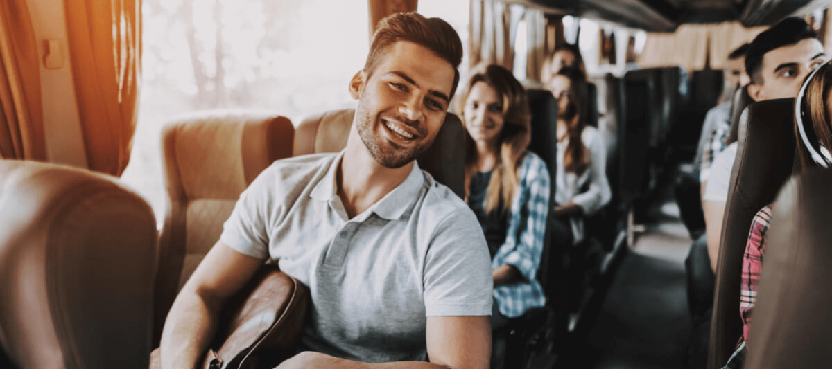 smiling man sitting on a Charter Bus